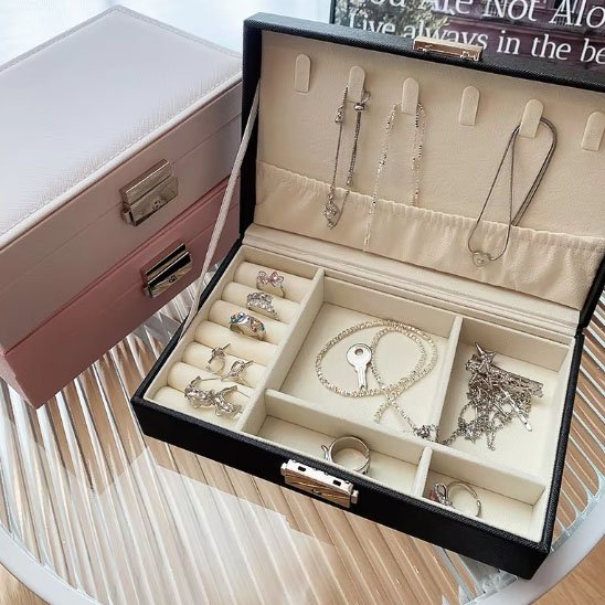 Boite a bijoux noir ouverte avec des bijoux rangés