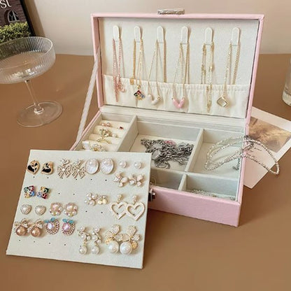 Boite a bijoux rose ouverte avec bijoux rangés 