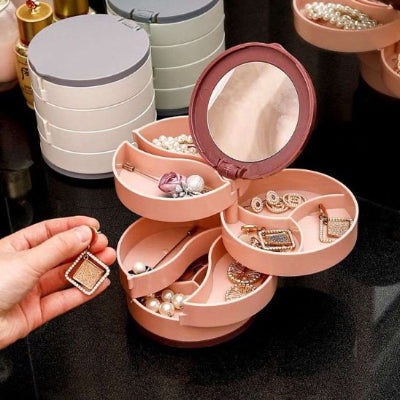 Boite a bijoux rose ouverte avec des bijoux 