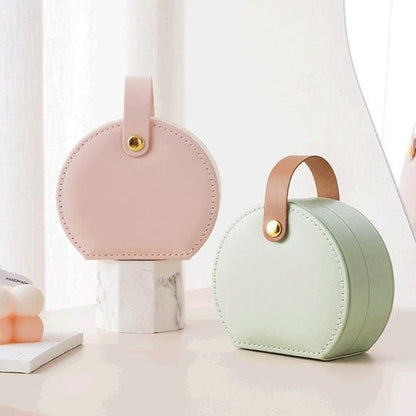 Boite a bijoux vert et rose posé sur table