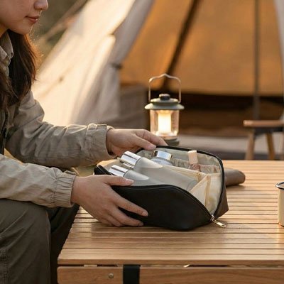 Trousse de toilette femme ouverte femme a l'exterieur s'en sert