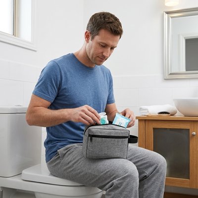 trousse de toilette homme assis dans salle de bain utilise sa trousse